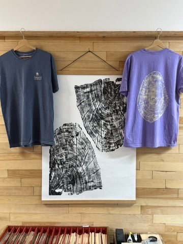 Takumi T-shirts displayed alongside original tree-ring artwork in the showroom